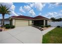 Inviting single-Gathering home with a neutral exterior, a red roof, and a two-car garage at 664 Mission Hills Trl, The Villages, FL 32162