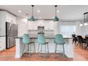 Bright kitchen with stainless steel appliances, modern pendants, and beautiful hardwood flooring at 678 Blackstone St, Minneola, FL 34715