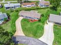 Aerial view of the property showcasing its spacious lawn, landscaping, and extended driveway at 71 Stone Haven Ct, Leesburg, FL 34788