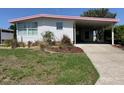 White home showing a carport, front yard, and easy access to outdoor activities at 715 Surrey Pl, Leesburg, FL 34748
