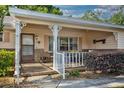 Inviting front porch, detailed columns, cozy seating area, and well-maintained landscaping at 8738 Sw 95Th Ln # B, Ocala, FL 34481