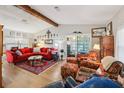 Spacious living room with wood flooring, beamed ceilings, and a comfortable seating area at 1 Aberdeen Cir, Leesburg, FL 34788
