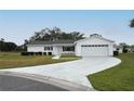 Inviting single-story home with a manicured lawn and long driveway to a two-car garage at 10442 Se 179Th Pl, Summerfield, FL 34491