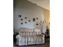 Living room featuring a sofa with a high ceiling wall decorated with Gathering photos and lamps at 1051 S Highland St # D-E, Mount Dora, FL 32757