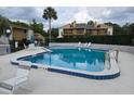 Community pool surrounded by lounge chairs and lush greenery; great for relaxing at 1051 S Highland St # D-E, Mount Dora, FL 32757