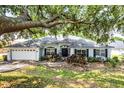 Charming single story home with lush landscaping, shutters, and a two car garage at 11126 Oakshore Ln, Clermont, FL 34711