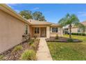 Inviting entrance with a landscaped walkway and a charming covered porch with tiled flooring at 12687 Se 90Th Ter, Summerfield, FL 34491