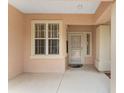 Covered front porch featuring a white framed window, matching door, and concrete flooring at 12687 Se 90Th Ter, Summerfield, FL 34491