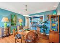 Charming dining room showcasing hardwood floors, bright colors, and seamless transition to the kitchen at 1301 North Ave, Tavares, FL 32778