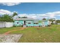 Attractive one-story home with light blue siding, complemented by green lawn and blue skies at 1301 North Ave, Tavares, FL 32778