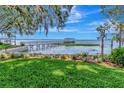 Picturesque backyard with lush lawn leading to a private wooden dock on a serene lake at 1341 W Lakeshore Dr, Clermont, FL 34711