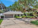 Charming single-story home with a two-car garage, verdant landscaping, and a spacious driveway at 1341 W Lakeshore Dr, Clermont, FL 34711