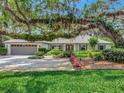 Beautiful home with a well-manicured lawn, mature trees, and an attached two-car garage at 1341 W Lakeshore Dr, Clermont, FL 34711