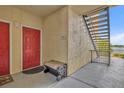 Exterior view of a unit featuring a red front door with a bench and stairs to the upper unit at 1460 Lake Shadow Cir # 7102, Maitland, FL 32751