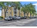 Exterior view of building featuring parking lot with an array of vehicles under mature shade trees at 1460 Lake Shadow Cir # 7102, Maitland, FL 32751