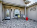 Inviting front porch with decorative tile flooring, seating, and a stylish front door at 17563 Se 122Nd Ter, Summerfield, FL 34491