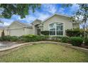 Lovely home showcasing manicured landscaping, a neutral color palette, and architectural details at 1828 Hollow Branch Way, The Villages, FL 32162