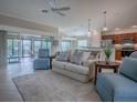 Open-concept living room with comfortable seating, neutral decor, and access to the outdoor patio at 2044 Larkwood Ct, The Villages, FL 32162