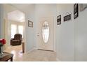 Bright foyer featuring tile flooring, decorative front door with sidelights, and a glimpse into the cozy living area at 21646 Stirling Pass, Leesburg, FL 34748