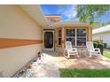 Inviting front porch with rocking chairs, a small table, and decorative accents creating a cozy outdoor space at 21646 Stirling Pass, Leesburg, FL 34748