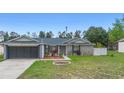 Inviting single-Gathering home featuring landscaped front yard and a two-car garage on a sunny day at 2304 Clementine Trl, Clermont, FL 34714