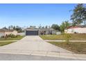 Lovely home boasts a long driveway, attached garage, and neatly landscaped front yard at 2304 Clementine Trl, Clermont, FL 34714