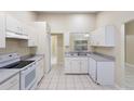 Clean and spacious kitchen features white cabinets, ample counter space, and tile flooring at 2304 Clementine Trl, Clermont, FL 34714
