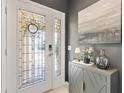Elegant front door with decorative glass and stylish hardware, complemented by a modern cabinet and tasteful decor at 2325 Kenya St, The Villages, FL 32162