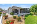 Outdoor view of a home with gravel landscaping, screened lanai and an attached garage at 2348 Riley Rd, The Villages, FL 32162