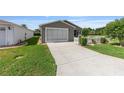Charming one-story home featuring an attached garage and well-manicured lawn at 2348 Riley Rd, The Villages, FL 32162