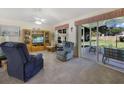 Cozy living room with a plush seating arrangement, ceiling fan, and sliding doors to the outdoor patio at 239 Juniper Way, Tavares, FL 32778
