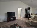 Open-concept living space features modern flooring, a large television, and a view into the dining area at 254 Locust Pass Dr, Ocala, FL 34472