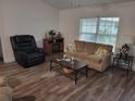 Cozy living room with a comfortable reclining chair, decorative fireplace, and sofa with colorful pillows at 254 Locust Pass Dr, Ocala, FL 34472