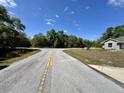 Street scene with a view of a tree-lined lot at 254 Locust Pass Dr, Ocala, FL 34472