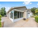 Rear view of the property featuring a large patio, attached two car garage and rear screened in porch at 2564 Red Cedar Ln, The Villages, FL 32162