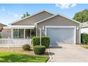 Charming single-story home featuring a well-manicured lawn and a white picket fence at 2564 Red Cedar Ln, The Villages, FL 32162