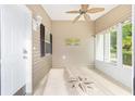 Bright sunroom with a decorative compass design on the floor and a tropical ceiling fan at 2564 Red Cedar Ln, The Villages, FL 32162