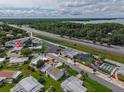 Aerial view of a community featuring a pool, tennis courts, and proximity to both a major highway and a large lake at 2706 Vindale Rd, Tavares, FL 32778