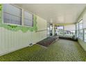 Enclosed sunroom featuring large windows, unique green carpet and wallpaper, with an access ramp and a view of the yard at 2706 Vindale Rd, Tavares, FL 32778