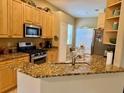 Well-lit kitchen featuring granite countertops, stainless steel appliances, and wooden cabinets at 3083 Pinnacle Ct, Clermont, FL 34711