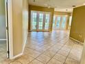 Bright living room with tile floors and natural light from the French doors at 3083 Pinnacle Ct, Clermont, FL 34711
