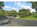 Charming single-story home with a well-manicured lawn and covered carport, nestled among mature trees at 33637 E Lake Joanna Dr, Eustis, FL 32736
