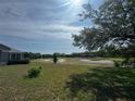 Expansive backyard showcasing a scenic golf course view, and proximity to mature trees at 33818 Venice Ln, Sorrento, FL 32776