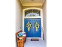 Inviting double front doors, adorned with wreaths, alongside a bench and welcome sign at 33818 Venice Ln, Sorrento, FL 32776