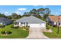 An elevated view of a well-maintained home featuring a gray roof, green lawn, and attached three car garage at 3393 Talley Ridge Dr, The Villages, FL 32162
