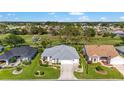 An elevated shot showcases a charming home near a golf course with lush landscaping at 3393 Talley Ridge Dr, The Villages, FL 32162