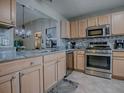 Modern kitchen with stainless steel appliances, granite countertops, and tile backsplash at 3432 Fairfield St, The Villages, FL 32162