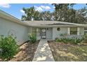 Inviting front entrance with a well-lit walkway, decorative landscaping, and unique architectural details at 36482 Doral Dr, Grand Island, FL 32735