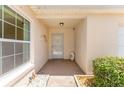 Inviting front porch with neutral tones, manicured shrubs, and a glimpse of natural light through a large window at 403 Duarte Ln, The Villages, FL 32159