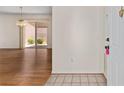 A glimpse of the living room with light tile leading to wood floors with access to an outdoor patio at 403 Duarte Ln, The Villages, FL 32159